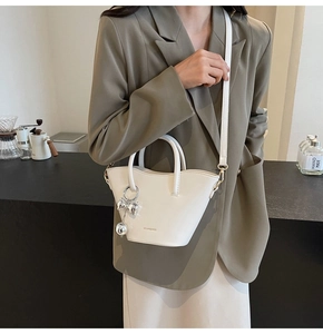 Detail of white bucket bag with silver bow charm and Solar & Miss logo branding