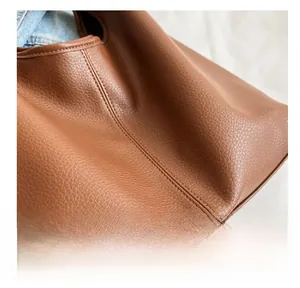 Detailed macro view of high-quality brown litchi pattern leather with precision stitching