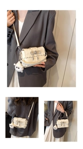 Détail du sac bandoulière crème avec nœud scintillant et porte-clés pompon doux