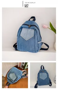 Detailed view of light blue denim backpack with trapezoid pocket and metal zipper