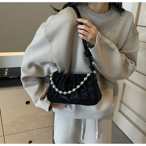 Détail du sac nuage plissé noir avec chaîne à perles métalliques et tissu brillant