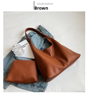 Brown lychee leather hobo bag and matching zip pouch displayed with a magazine