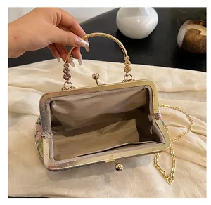 Detail of vintage embroidery bag featuring pearl handle and beige herringbone lining inside