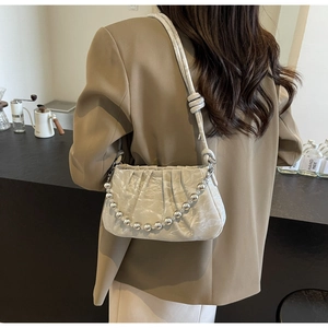 Détail du sac à main plissé beige avec chaîne à perles argentées et similicuir souple