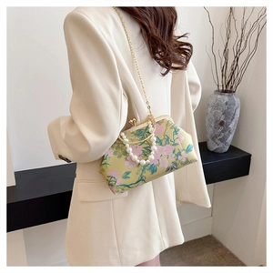 Detailed view of vintage floral silk handbag with pearl handle and golden chain strap