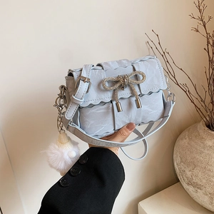 Sac bandoulière bleu clair tissé avec nœud en strass et pompon en fourrure blanche