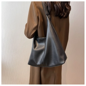 Close-up of black lychee grain leather hobo bag showing texture and soft structure