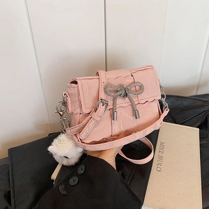 Sac bandoulière rose en cuir plissé avec boucle en nœud de diamant et pendentif en peluche