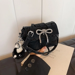 Sac bandoulière noir plissé avec un nœud en strass brillant et un pompon doux