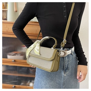 Detail of vintage olive green square bag with woven texture and floral scarf handle