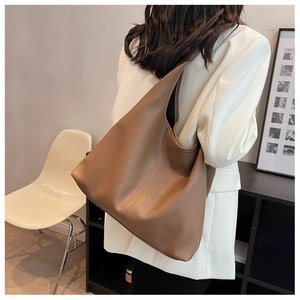 Brown litchi grain leather tote bag shown on model for daily commuting style