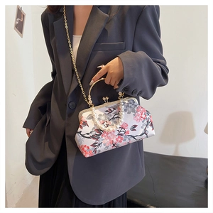Macro view of floral pattern handbag with pearl handle and golden clasp detail