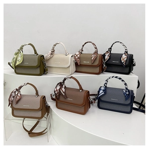Multi-color vintage crossbody bags with silk scarf handles on white display stands