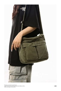 Detail view of large front pockets and durable canvas texture on army green crossbody bag