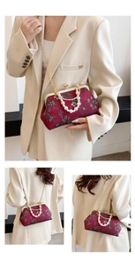 Detail of vintage shell-shaped evening bag with pearl handle and floral embroidery