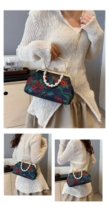 Detailed view of floral jacquard fabric with pearl handle and golden chain strap