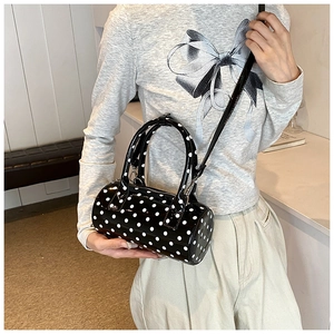 Polka dot Boston bag shown as a crossbody by a model for a stylish size comparison