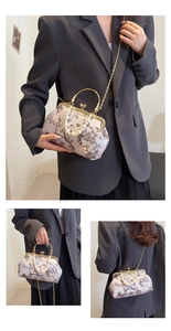 Detail of floral jacquard clutch with pearl handle and golden kiss-lock closure
