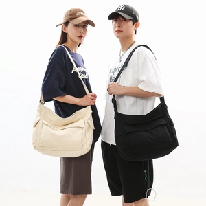 Unisex large capacity canvas messenger bags in beige and black with adjustable wide straps