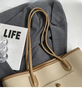 Detail of comfortable shoulder straps and reinforced stitching on a beige tote bag