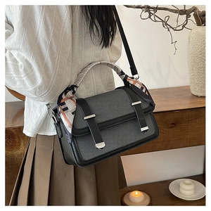 Detailed view of women's gray striped crossbody bag with printed silk scarf handle