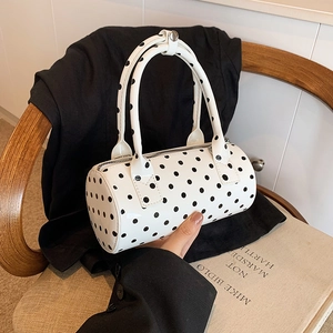Stylish polka dot barrel handbag in white and black patent leather with top handles