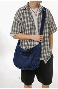 Detail of dark blue denim tote bag featuring yellow stitching and functional side pocket