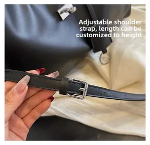 Détail de la bandoulière réglable en cuir noir avec boucle en métal argenté du sac