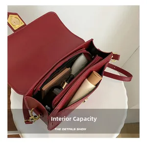 Detailed interior of burgundy saddle bag showing compartments and gold twist lock