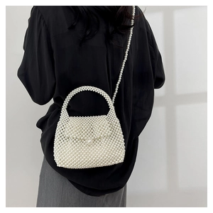 Détail du sac à bandoulière en perles fait main avec poignée perlée sur un mannequin