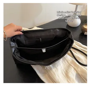 Vue de dessus du sac en cuir noir montrant le rangement interne et les poches zippées