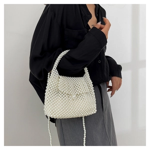 Détail d'un sac à main en perles tressées avec rabat et poignée élégante en perles