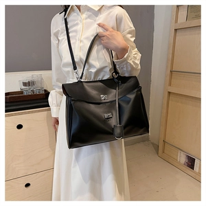 Détail d'un grand sac cabas noir avec boucle rotative argentée et bandoulière amovible
