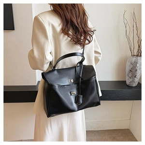 Détail d'un sac cabas noir minimaliste avec fermoir argenté et texture en cuir mat