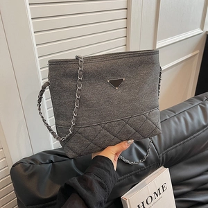 Gray denim tote bag with silver chain strap and classic quilted pattern for women