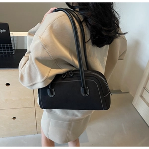 Detail of a vintage black frosted shoulder bag with white contrast stitching and soft curves