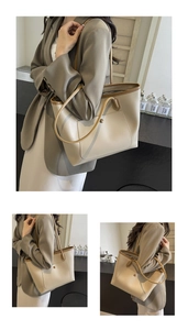 Detail of beige tote bag with brown trim and magnetic front pocket for office commute
