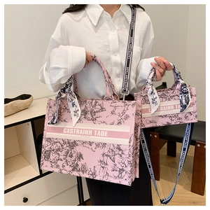 Detailed macro view of pink floral canvas tote with vintage embroidery and wide strap