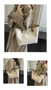 Detail of a large capacity tote bag with beige body and brown shoulder straps