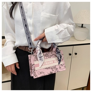 Close-up of pink floral canvas tote with embroidered strap and silk scarf detail