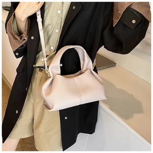 Detail of light beige lychee pattern leather handbag with elegant pleats and stitching