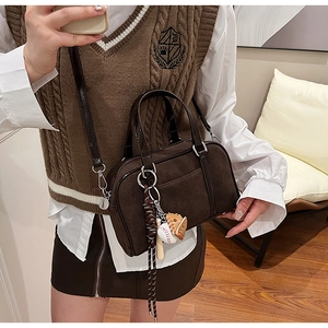 Detail of dark brown frosted leather Boston bag with baseball theme pendant charm