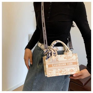 Close-up of beige canvas mini tote with vintage floral print and silk scarf handle detail