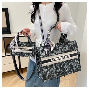 Detail of vintage canvas tote set with black floral print and contrast stripe branding