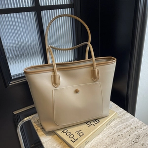 Minimalist cream tote bag with brown straps and front pocket for daily commute
