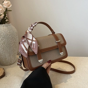 Brown leather and beige woven crossbody bag with pink scarf wrap on the handle