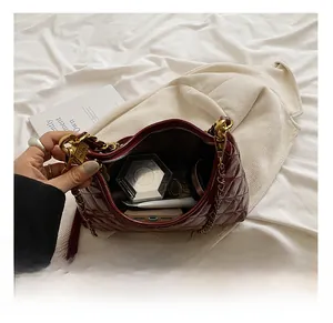 Internal capacity of burgundy quilted hobo bag showing smartphone and cosmetics inside