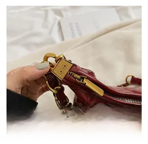 Macro detail of wine red quilted faux leather and vintage gold chunky chain hardware