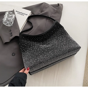 Détail d'un sac cabas noir avec strass argentés dégradés sur une veste de costume grise