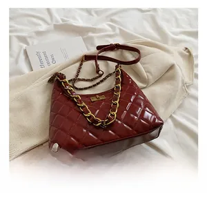 Detailed view of red quilted bucket bag with high-gloss finish and gold chain strap